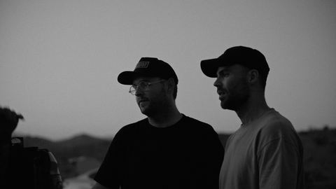 Josh and Tommy in caps, silhouetted against the sky
