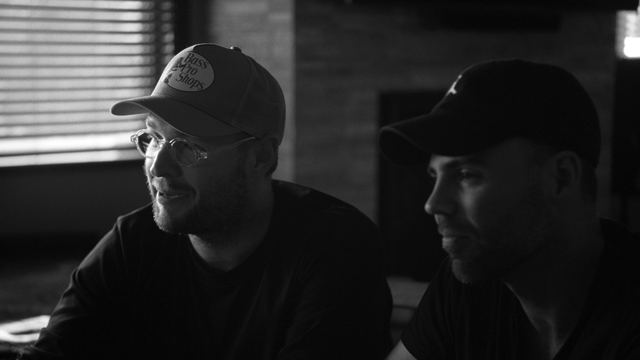 Josh and Tommy listening across a table during a conversation